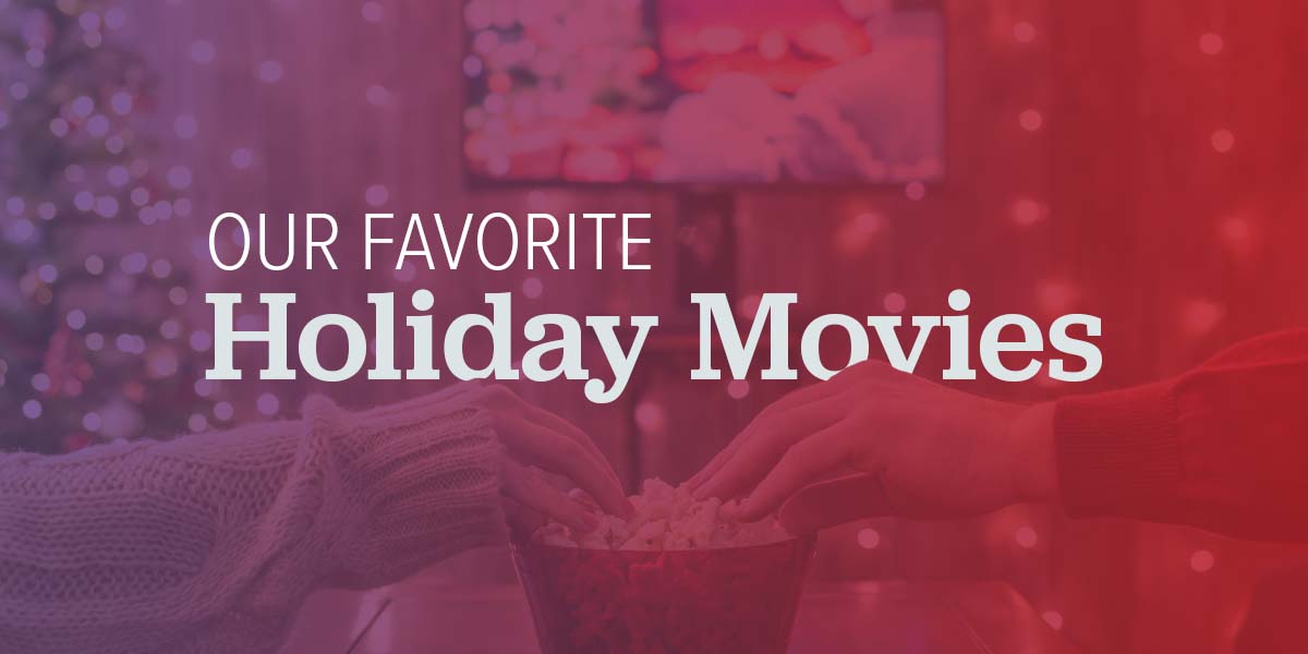 Two people sharing popcorn and watching a movie.
