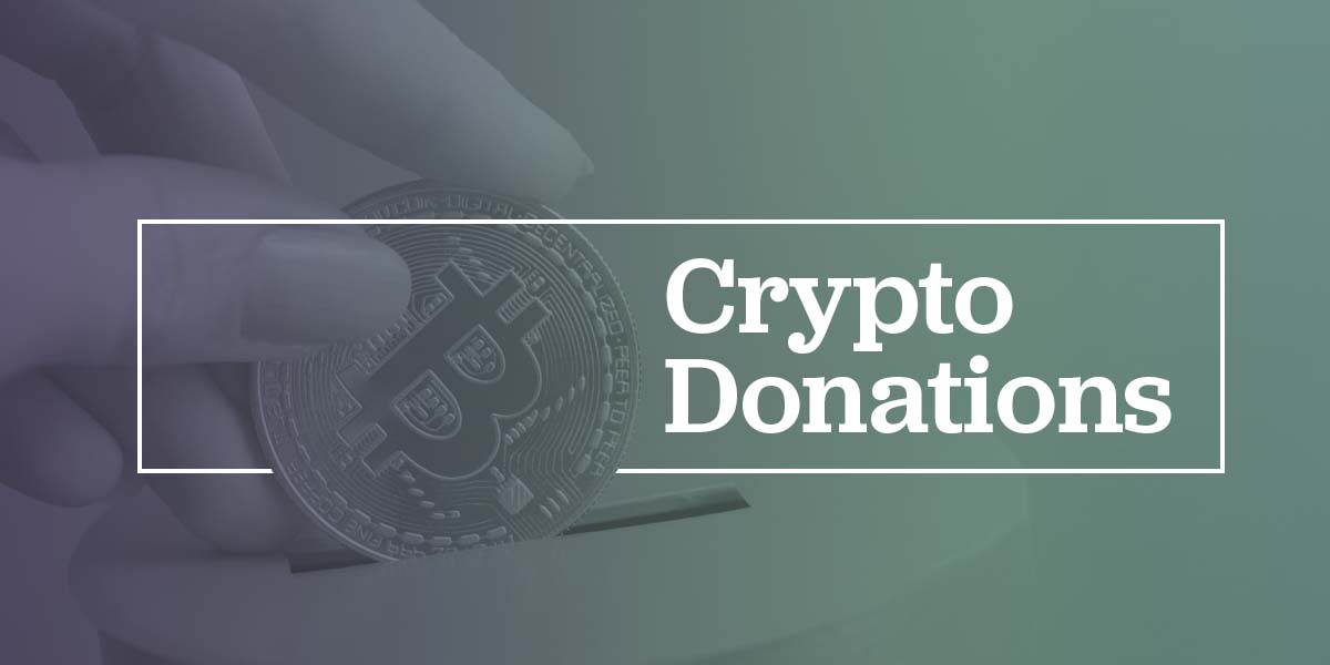 Closeup of a hand putting a bitcoin in a box.