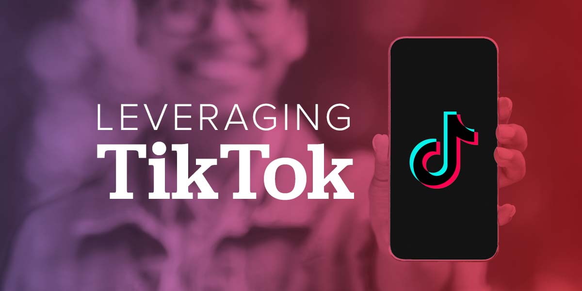 A person holding out their phone with the TikTok app on it.